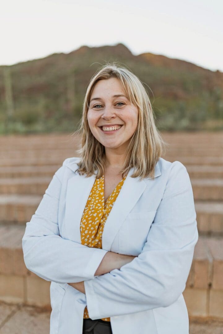 Smiling woman with arms crossed outdoors