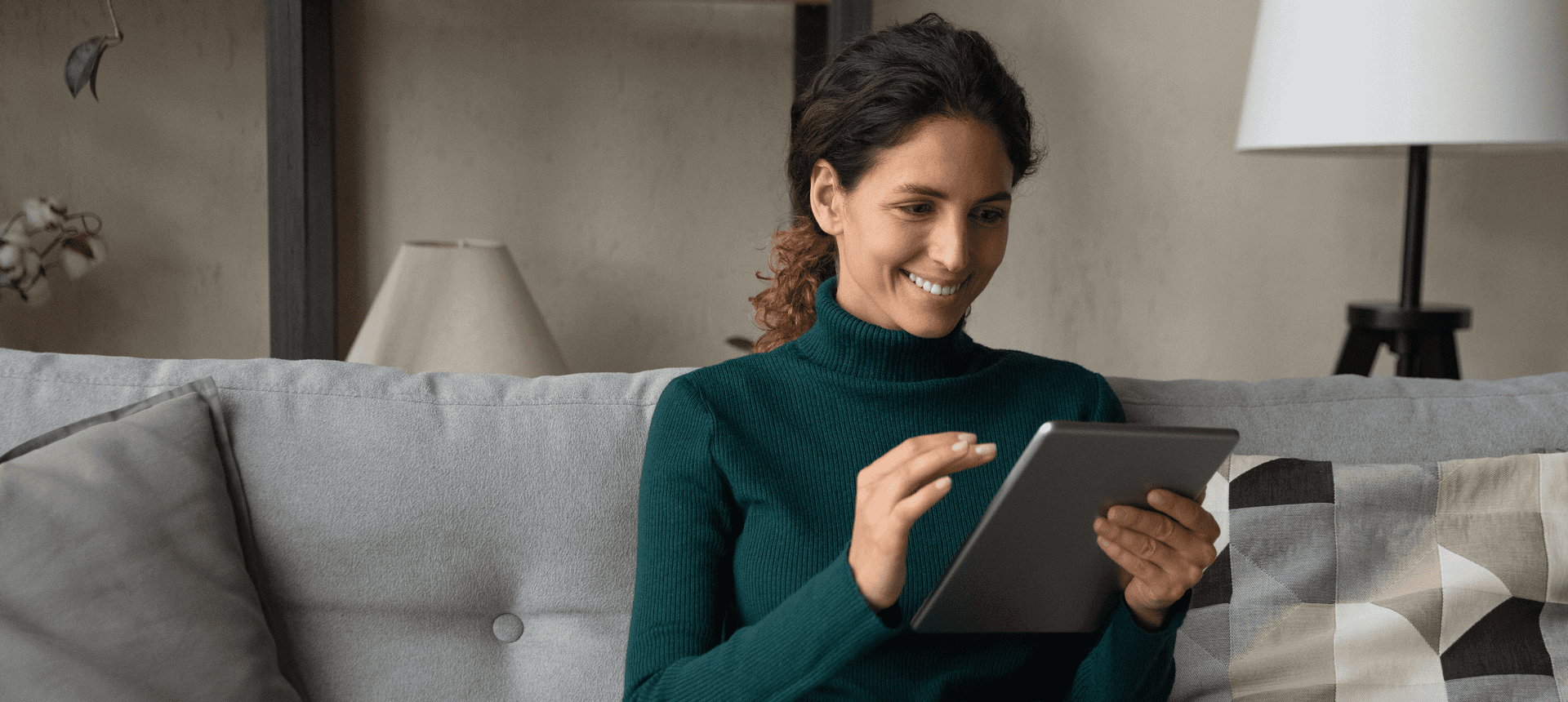 Relaxed woman sitting on a couch with tablet