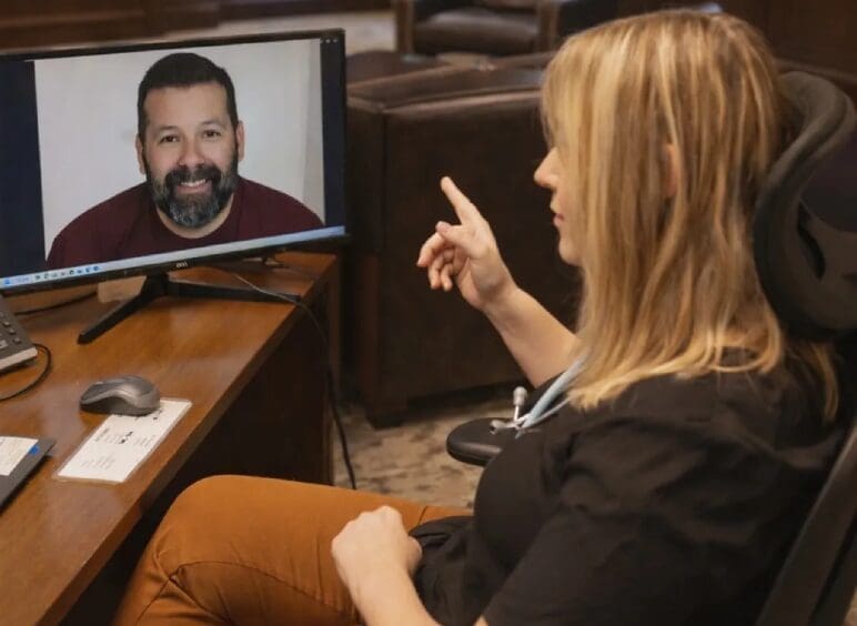 Woman pointing at man on computer screen
